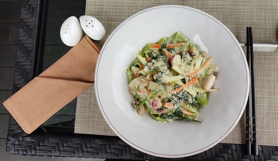 A colorful vegetable salad beautifully plated, served with chopsticks for an elegant dining experience.